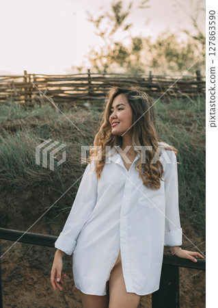 young Asian woman in white during sunset on rural path, soft golden light highlights her hair and creates a warm glow, concept of personal branding, wellness, natural beauty young Asian woman in white during sunset on rural path, soft golden light highlights her hair and creates a warm glow, concept of personal branding, wellness, natural beauty 127863590