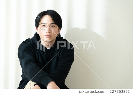 man sitting by the wall 127863831