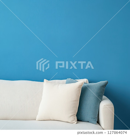 Modern living room with blue wall and cozy couch 127864074