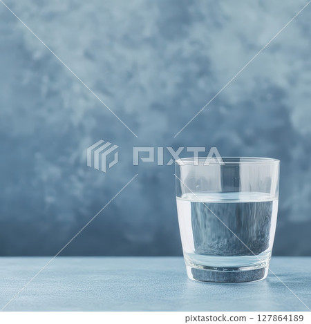 Glass of water on a blue surface with texture Glass of water on a blue surface with texture 127864189