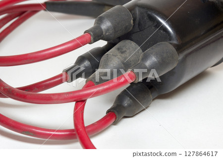spark plug wires, red, high tension cables, closeup on rubber boots spark plug wires, red, high tension cables, closeup on rubber boots 127864617