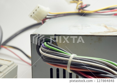 computer ATX non-modular power supply unit front side with ventilation holes, with directly connected colored connectors for drives 127864848