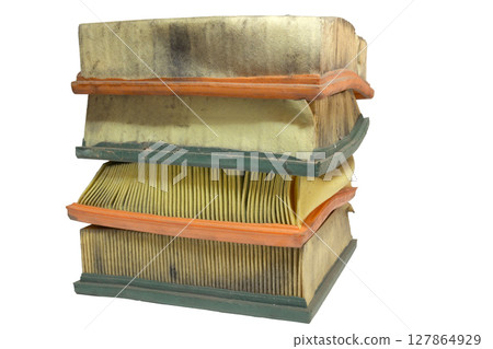 old engine air filters neat stack. Paper filter, dusty, worn, crumpled while replacing, isolated on white background 127864929