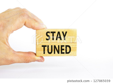 Stay tuned symbol. Concept words Stay tuned on wooden blocks on a beautiful white table white background. Businessman hand. Business, support, motivation, psychological stay tuned concept. Copy space. Stay tuned symbol. Concept words Stay tuned on wooden blocks on a beautiful white table white background. Businessman hand. Business, support, motivation, psychological stay tuned concept. Copy space. 127865039