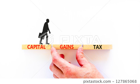 Capital gains tax symbol. Concept words Capital gains tax on beautiful wooden block. Businessman's hand. Beautiful white background. Business and capital gains tax concept. Copy space. Capital gains tax symbol. Concept words Capital gains tax on beautiful wooden block. Businessman's hand. Beautiful white background. Business and capital gains tax concept. Copy space. 127865068