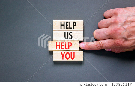 Help you symbol. Concept words phrase Help us help you on beautiful wooden blocks. Beautiful grey paper background. Businessman's hand. Business Help you concept. Copy space. 127865117
