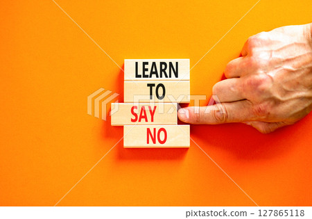 Learn to say no symbol. Concept words phrase Learn to say no on beautiful wooden blocks. Beautiful orange paper background. Businessman's hand Business psychological Learn to say no concept Copy space 127865118