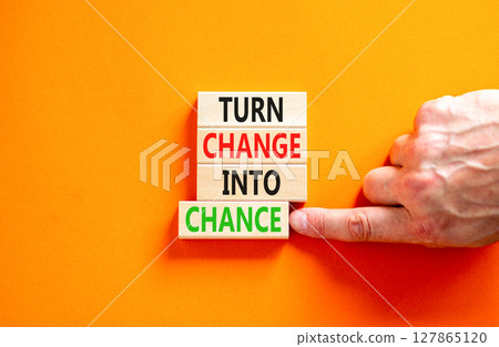 Turn change into chance symbol. Concept words phrase Turn change into chance on beautiful wooden blocks. Beautiful orange paper background. Business Turn change into chance concept. Copy space. 127865120