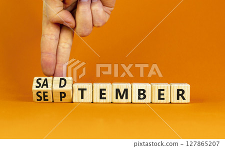 September is Sadtember symbol. Concept words September is Sadtember on beautiful wooden blocks. Beautiful orange background. Businessman hand. Business September is Sadtember concept. Copy space. 127865207