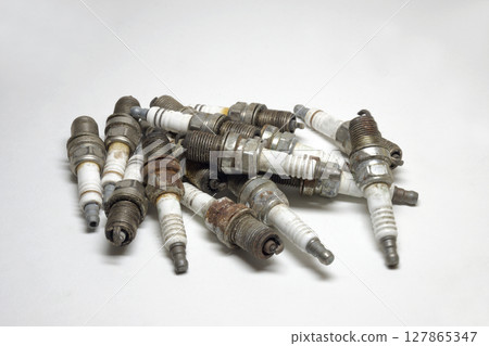 used copper spark plugs on white background. spark plugs big heap, old 127865347