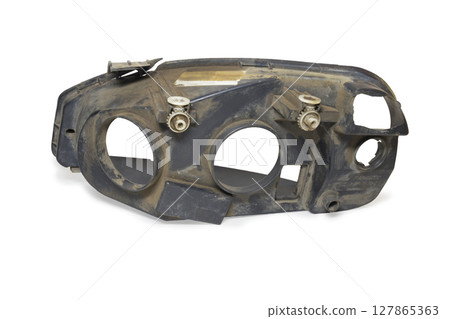 cracked headlight housing. black plastic, headlight regulator white gears. on white background, with clipping path 127865363