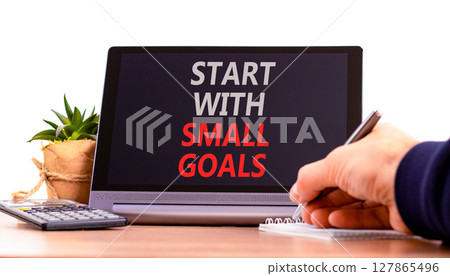 Start with small goals symbol. Concept words phrase Start with small goals on beautiful black tablet. Businessman's hand. Beautiful white background. Business Start with small goals concept Copy space 127865496