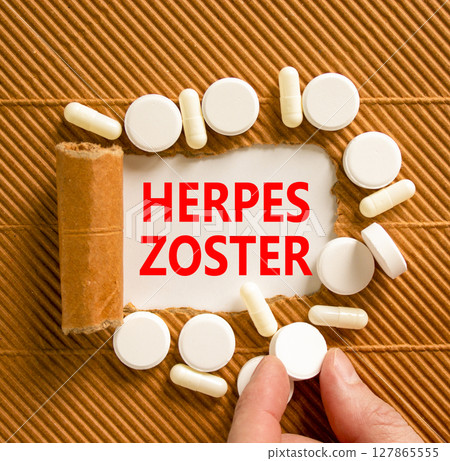Herpes zoster symbol. Concept words Herpes zoster on beautiful white paper. White pills tablets. Doctor's hand. Beautiful brown background. Medical healthy lifestyle herpes zoster concept. 127865555