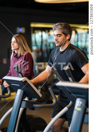 A man running on a treadmill at the gym. A man running on a treadmill at the gym. 127865809