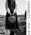 Girl standing with hat 127866901