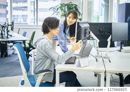 Male and female engineers in plain clothes working in the office 127866925