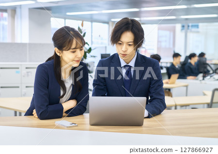 穿著西裝在辦公室工作的男性和女性商人 穿著西裝在辦公室工作的男性和女性商人 127866927