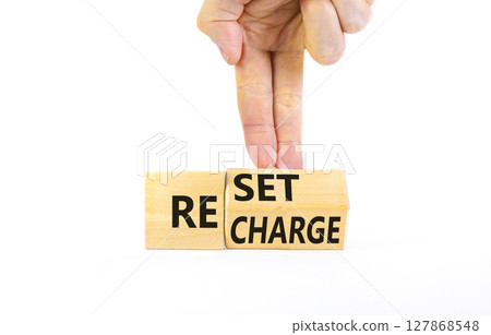 Reset and recharge symbol. Concept words Reset Recharge on beautiful wooden block. Beautiful white table white background. Businessman hand. Business reset and recharge concept. Copy space. 127868548