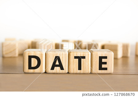 Date symbol. Concept word Date on beautiful wooden blocks. Beautiful wooden table white background. Business and date concept. Copy space. Date symbol. Concept word Date on beautiful wooden blocks. Beautiful wooden table white background. Business and date concept. Copy space. 127868670