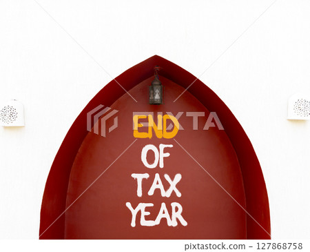 End of tax year symbol. Concept words phrase End of tax year on beautiful brown wall. Beautiful white wall background. Business End of tax year concept. Copy space. End of tax year symbol. Concept words phrase End of tax year on beautiful brown wall. Beautiful white wall background. Business End of tax year concept. Copy space. 127868758