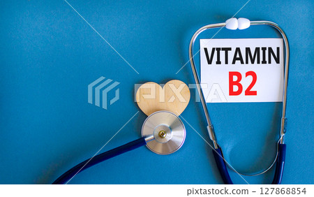 Vitamin B2 riboflavin symbol. Concept words Vitamin B2 on beautiful white card. Wooden heart and stethoscope. Beautiful blue background. Medical healthy lifestyle Vitamin B2 riboflavin concept. Vitamin B2 riboflavin symbol. Concept words Vitamin B2 on beautiful white card. Wooden heart and stethoscope. Beautiful blue background. Medical healthy lifestyle Vitamin B2 riboflavin concept. 127868854