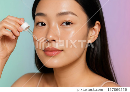 Woman Applying Serum to Her Face for Skincare Routine 127869256