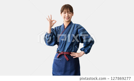 一位年輕的居酒屋/餐廳女員工擺出「OK」姿勢 一位年輕的居酒屋/餐廳女員工擺出「OK」姿勢 127869277
