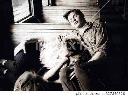 Vintage portrait of a young couple. Tired guy and girl are traveling in a suburban train carriage and sleeping. Retro photo from 1962. 127869328