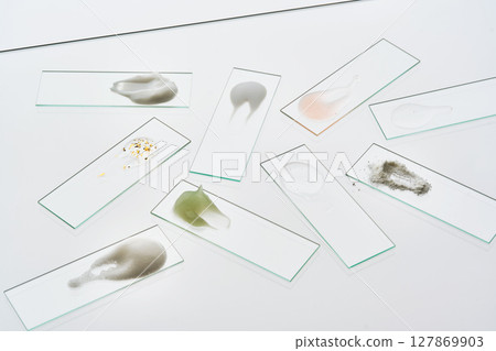 Textures of various cosmetic products on slides on a gray background. Textures of various cosmetic products on slides on a gray background. 127869903