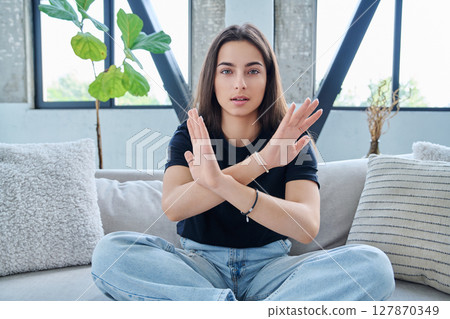 Young woman showing stop gesture with crossed arms Young woman showing stop gesture with crossed arms 127870349