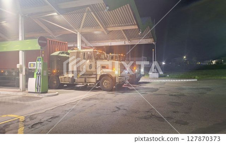 Military convoy on a road in Europe. Military armoured convoy at a petrol station. Movement of a military convoy to a military exercise within Europe. Defence and preparation for armed conflict in 127870373