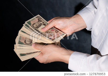 Man in work clothes holding money 127870953