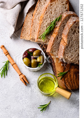 Fresh bread, olive oil and mix of olives. 127871202