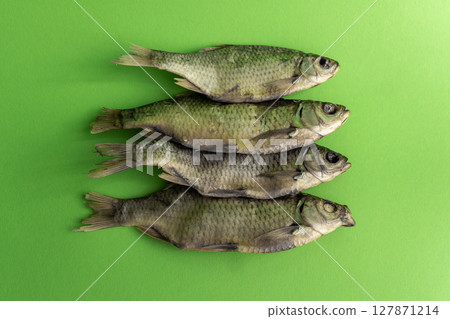 Dried fish for beer on a green background Dried fish for beer on a green background 127871214