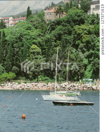 Enjoying a Sunny Day at Herceg Novi Beach With Boats and Lush Greenery in Montenegro 127871619