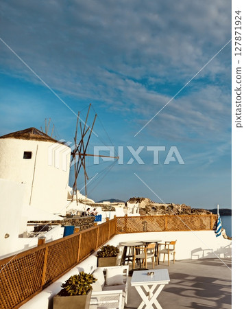 Cozy restaurant with a traditional windmill in Oia, Santorini Cozy restaurant with a traditional windmill in Oia, Santorini 127871924