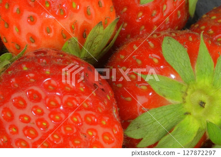 Macro shot of ripe red strawberries on a black background. Ripe strawberries on a black slate background. Close-up and top view 127872297
