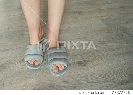 Woman in soft slippers on wooden floor, closeup. Space for text 127872798