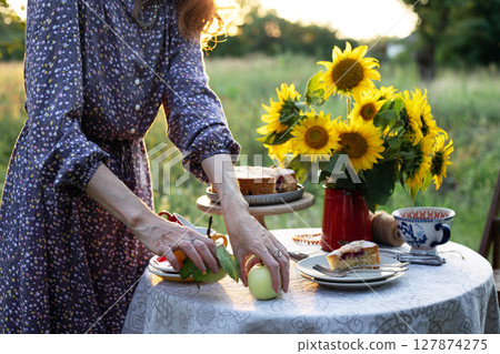 girl serving tea table in the garden girl serving tea table in the garden 127874275