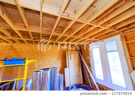 Room under construction displays wooden beams various materials, during renovation work progress. 127874854