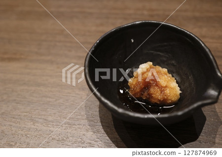 一小碗蘿蔔泥配柚子醋醬和一張木桌 127874969