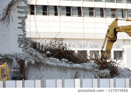 Demolition work site of a reinforced concrete building using heavy machinery 127874988
