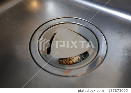 Food waste accumulated in the drain of the kitchen sink 127875055