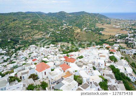 A rural town with striking white exterior walls at the foot of a small hill A rural town with striking white exterior walls at the foot of a small hill 127875438