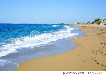 Beach scene with waves crashing Beach scene with waves crashing 127875473