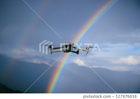 Drone taking photo of rainbow with a drone on high altitude grassland mountain top Drone taking photo of rainbow with a drone on high altitude grassland mountain top 127876838