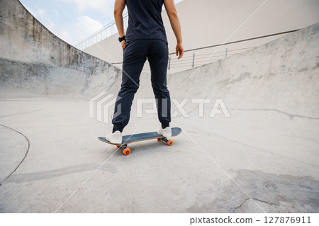 Skateboarder skateboarding at skatepark in city 127876911
