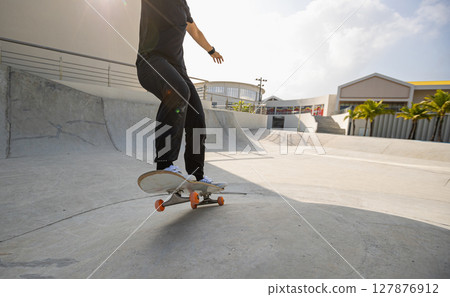 Skateboarder skateboarding at skatepark in city 127876912