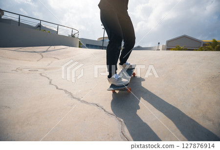 Skateboarder skateboarding at skatepark in city 127876914