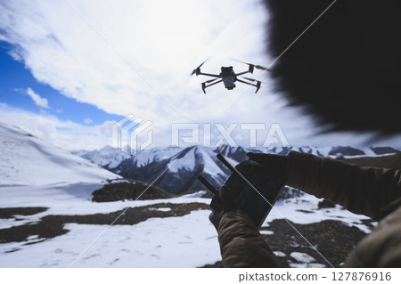 Flying drone in high altitude mountains Flying drone in high altitude mountains 127876916